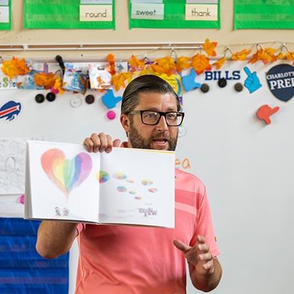 teacher reading a book to students