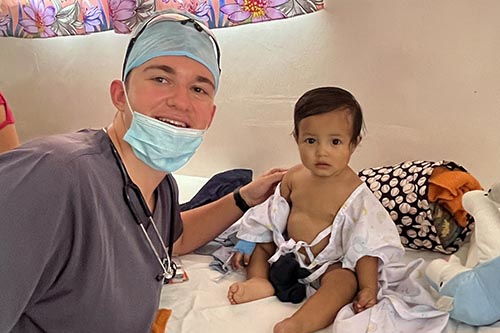Jeffrey wearing medical gear with a small child
